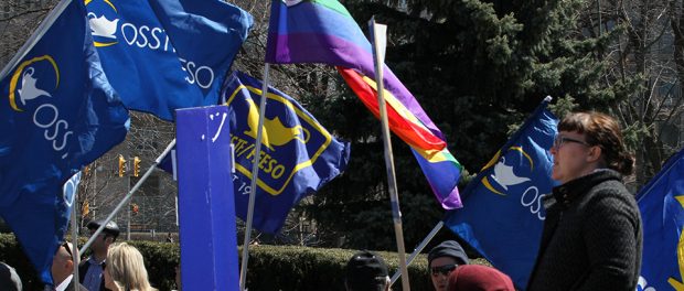 Photo of OSSTF/FEESO members marching with flags at Queen's Park.