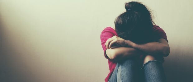 image of woman sitting on the floor depressed