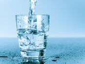 A photo of a glass with water being poured into it.