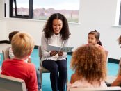 Photo of teacher reading to children in a classroom