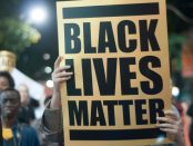 A protester holding up a sign that says Black lives matter