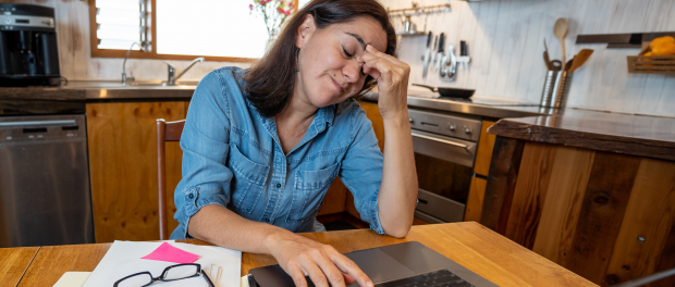 Stressed business woman working from home on laptop looking worried