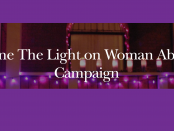 image of a city at night with candles with the words Shine the lights on woman abuse campaign