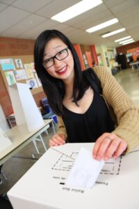 Asian woman with glasses voting