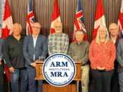 Retired OSSTF/FEESO Members standing up on a stage at Queens Park.