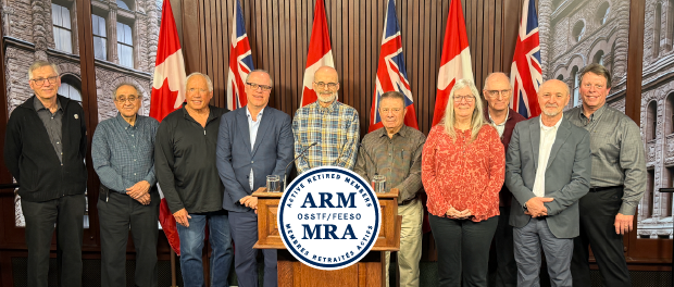 Retired OSSTF/FEESO Members standing up on a stage at Queens Park.
