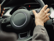 Hands holding a steering wheel in a car